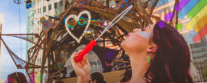 woman blowing bubbles at PRIDE parade