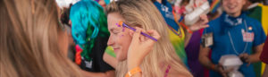 woman getting face painted at reggae festival