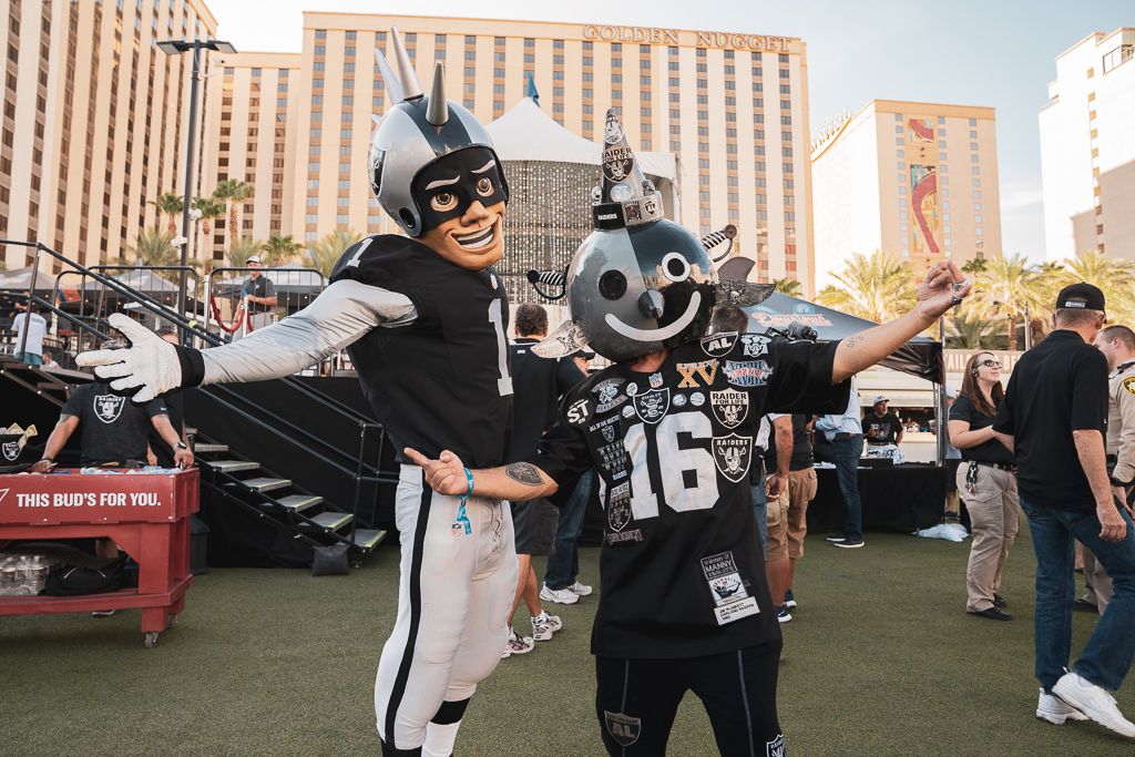 Raider mascot poses with fan.